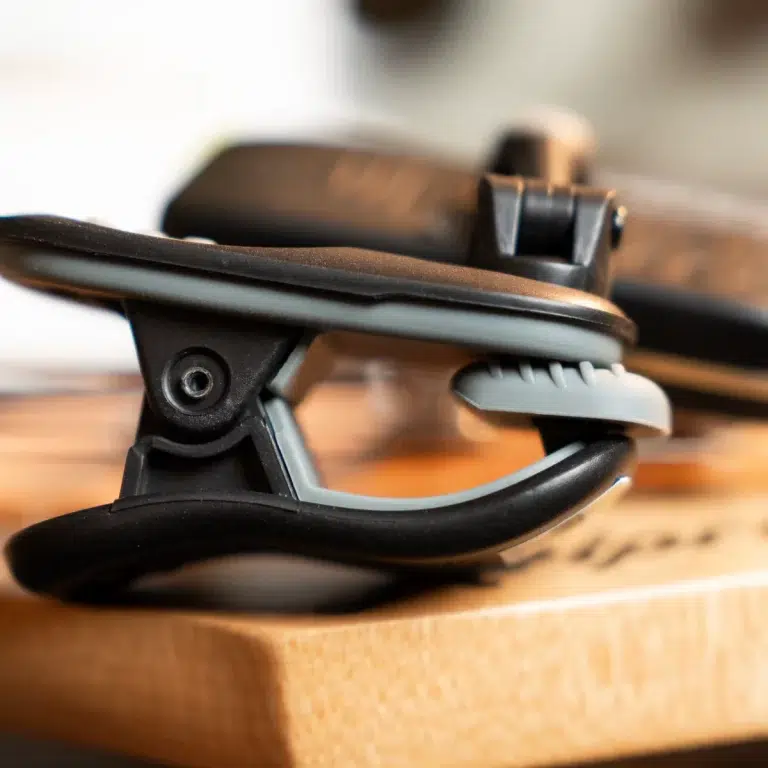 Close-up of a black and gray plastic clamp resting on a wooden surface, part of a mounting accessory. ขายราคาพิเศษ