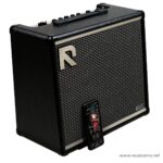 Black guitar amplifier with a striped grille, metal corner protectors, and a smartphone mounted on the front displaying a music app ลดราคาพิเศษ