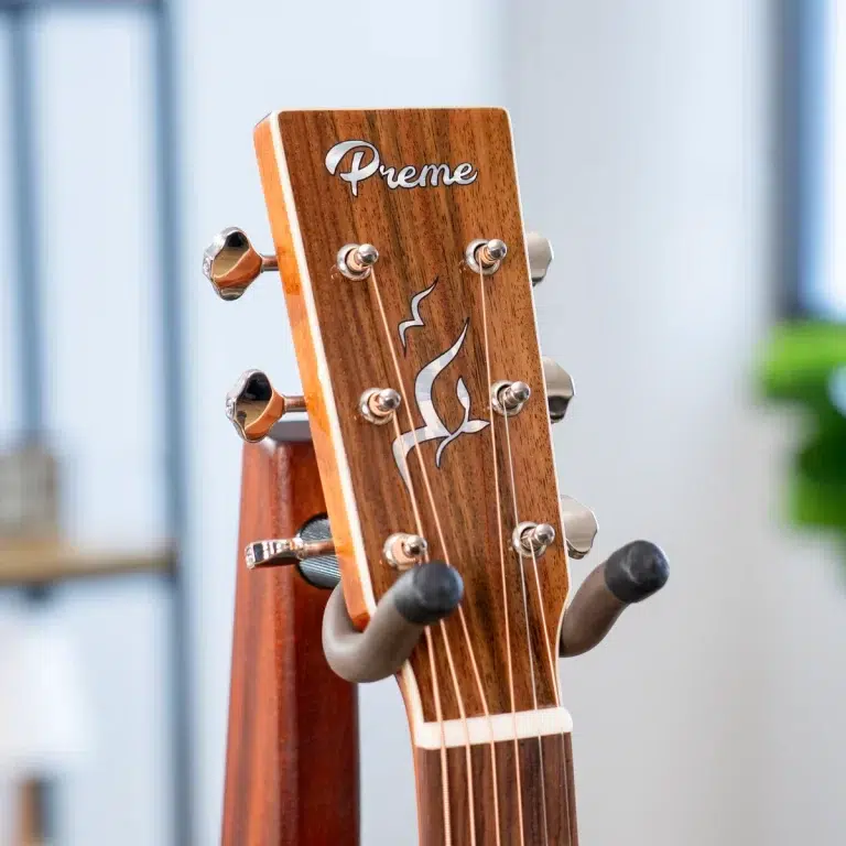 Close-up of a wooden guitar headstock with six silver tuning pegs and the word 'Preme' on the face, flamenco-style inlay in silver. ขายราคาพิเศษ