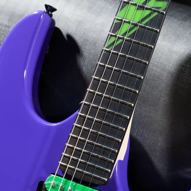 Purple electric guitar body with a green neck pickup and fretboard close-up showing silver frets and strings ขายราคาพิเศษ
