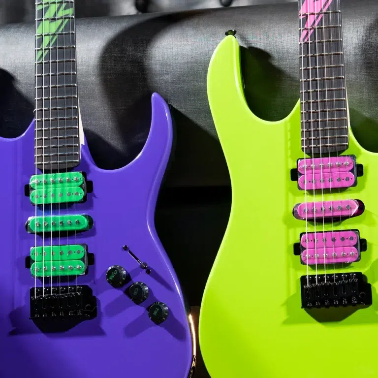 Two vibrant electric guitars—purple with green pickups and a neon-green guitar with pink pickups—leaning side by side against a dark backdrop. ขายราคาพิเศษ