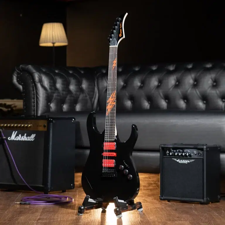Black electric guitar on a stand in a studio, with a Marshall amplifier and a tufted black sofa in the background. ขายราคาพิเศษ