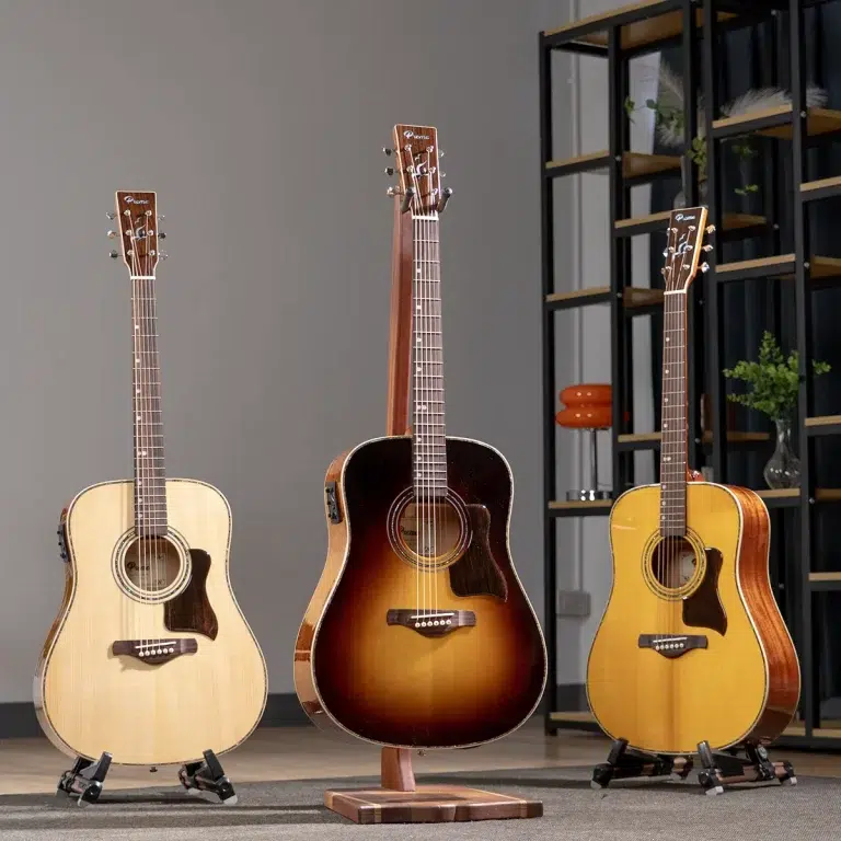 Three acoustic guitars on stands in a showroom, with a sunburst model center stage and light/amber guitars on either side. ขายราคาพิเศษ