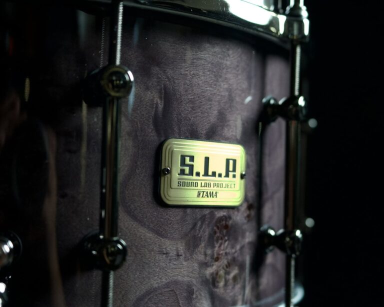 Close-up of a purple drum shell with a metallic badge reading 'S.L.A. Sound Lab Project Tama' attached to the side. ขายราคาพิเศษ