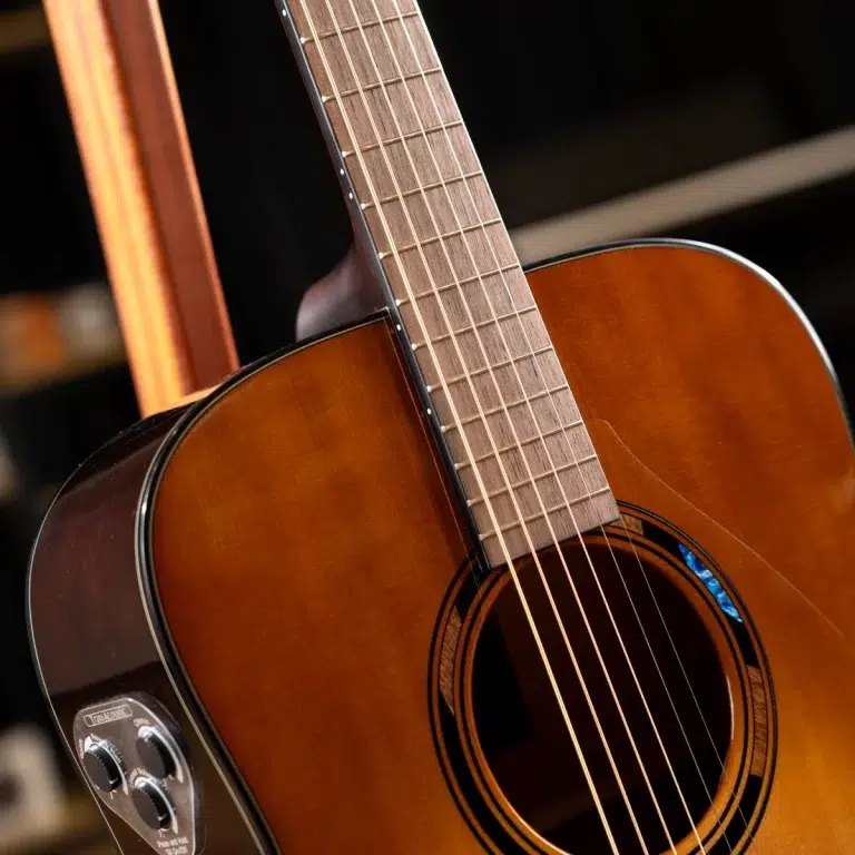 Acoustic guitar close-up showing neck across the body with six strings over the sound hole ขายราคาพิเศษ