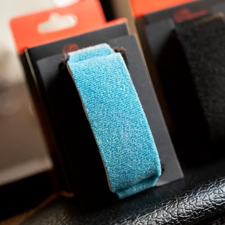 Close-up of a blue Velcro strap attached to black packaging on a display card ขายราคาพิเศษ