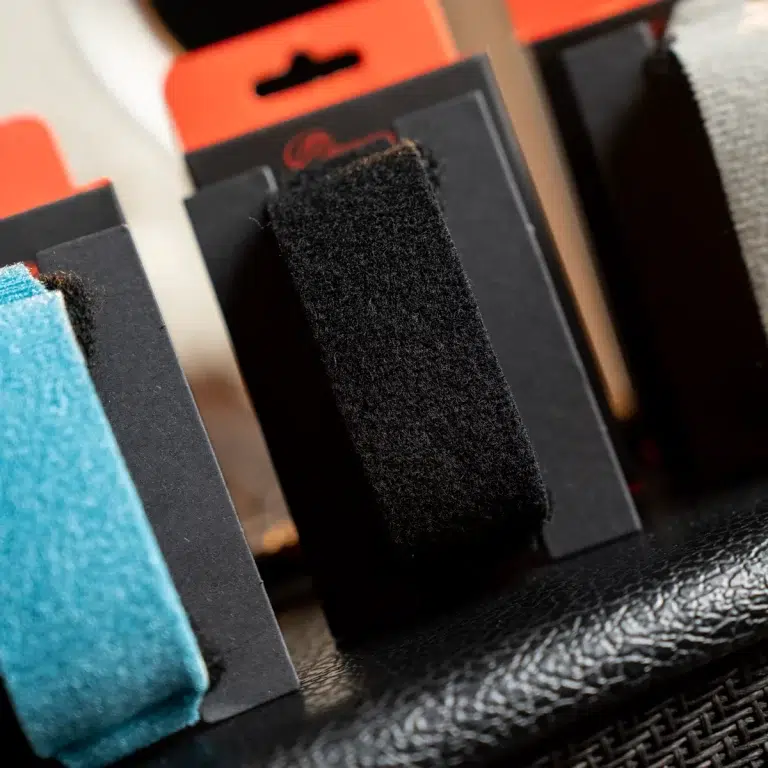 Close-up of rectangular foam pads (blue and black) arranged on a dark display stand in a retail setting. ขายราคาพิเศษ