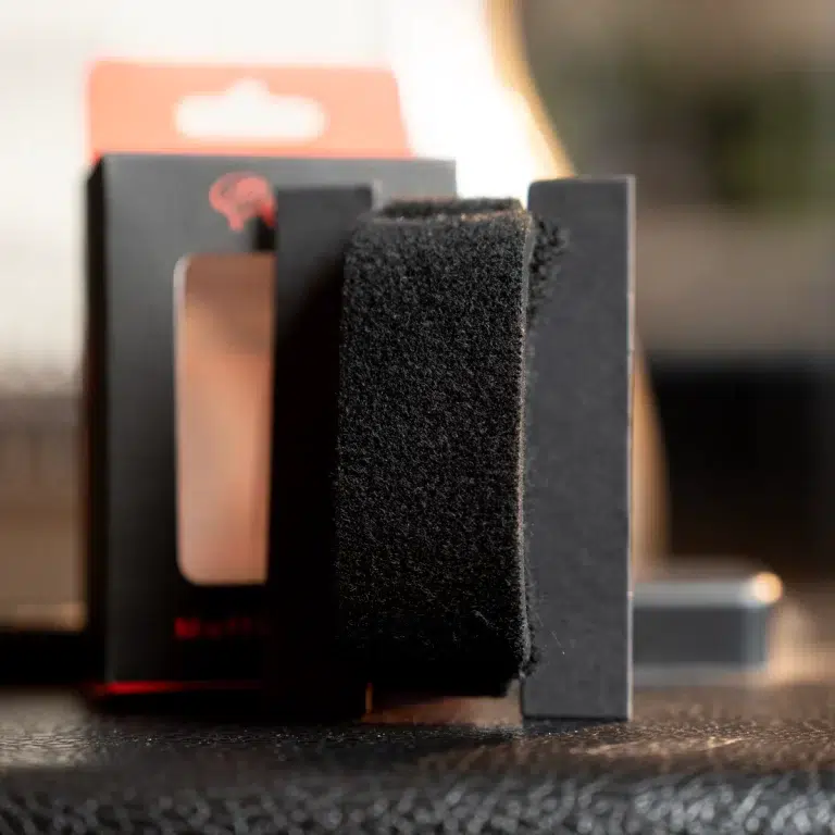 Close-up of black foam padding inside a product packaging box, with a dark panel behind it ขายราคาพิเศษ