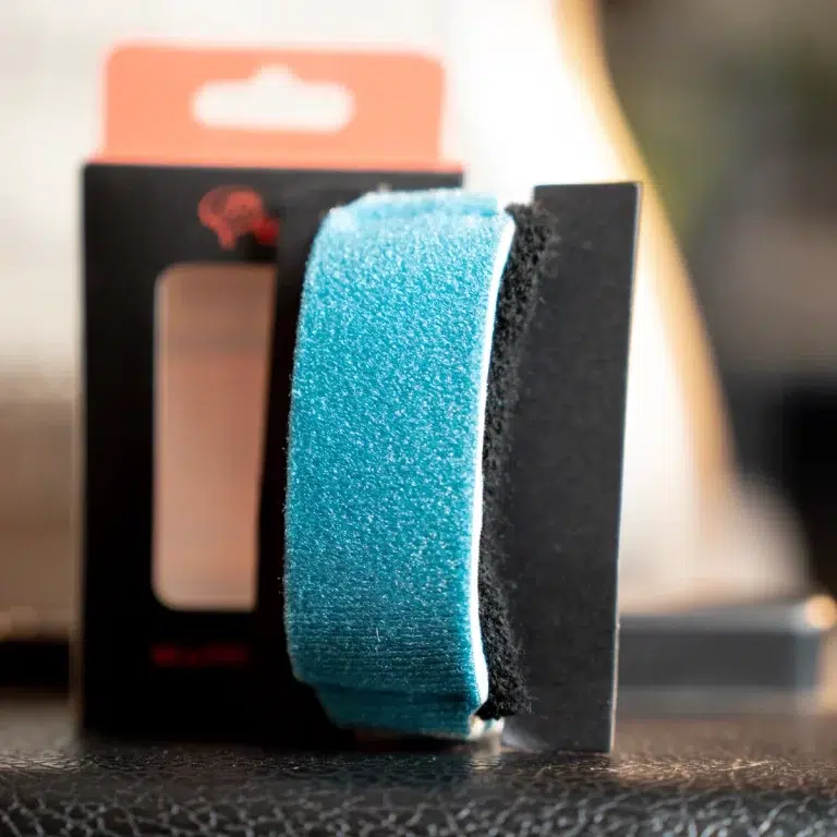 Close-up of a turquoise abrasive sanding pad attached to a black holder, ready for polishing or cleaning. ขายราคาพิเศษ