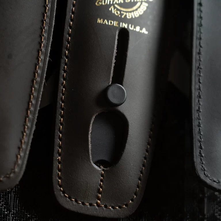 Close-up of a black leather holster or sheath with brown stitching and a round snap button, gold text 'Made in U.S.A.' ขายราคาพิเศษ