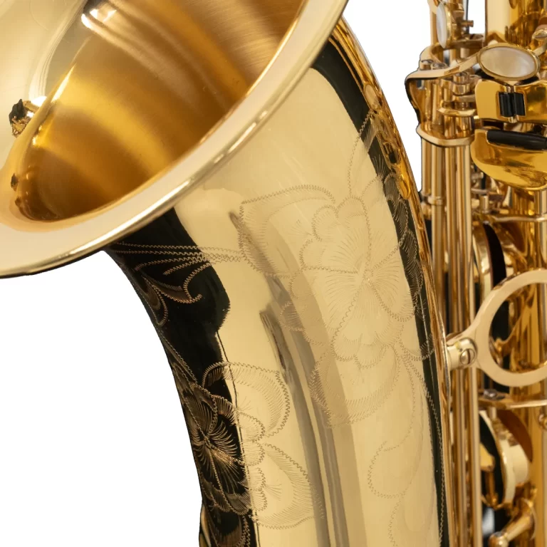 Close-up of a gold saxophone bell with engraved patterns and visible keywork on the right side. ขายราคาพิเศษ