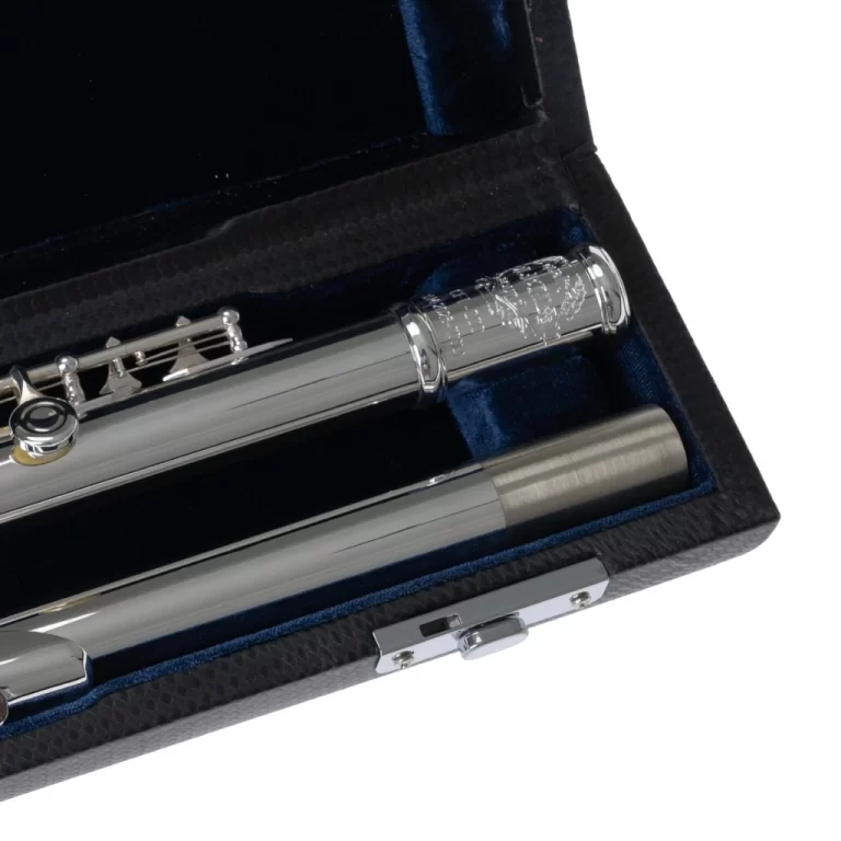 Close-up of a silver flute placed in a black, lined instrument case with blue interior padding, showing the headjoint and body sections. ขายราคาพิเศษ