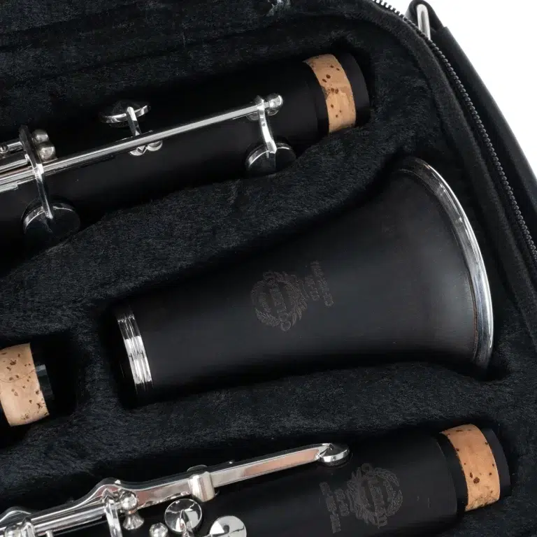 Close-up of a black clarinet in a padded case, showing cork joints and silver keys. ขายราคาพิเศษ