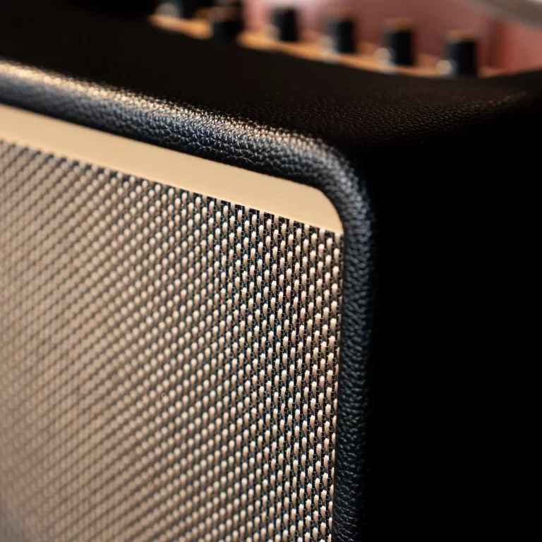 Close-up of a guitar amplifier speaker grille with textured fabric and black leather corner trim ขายราคาพิเศษ