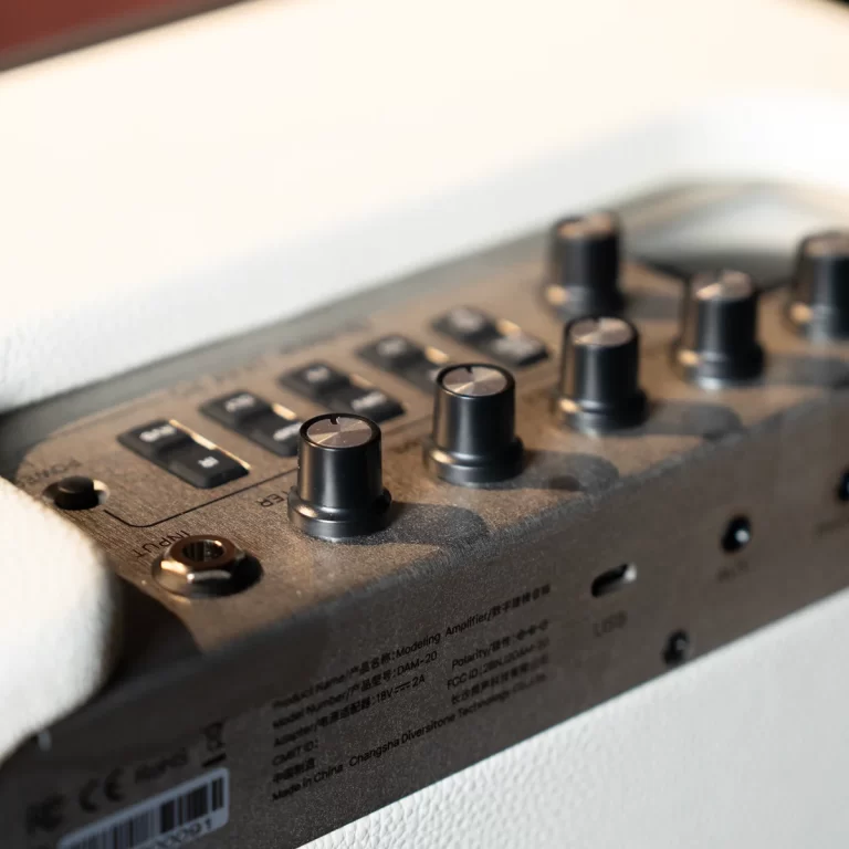 Close-up of a black audio mixer panel with several knobs and small switches, headphones resting nearby. ขายราคาพิเศษ