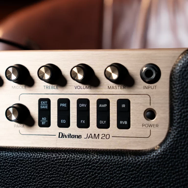 Close-up of a Divitone JAM 20 guitar amp control panel with knobs for middle, treble, volume, master and an input jack. ขายราคาพิเศษ