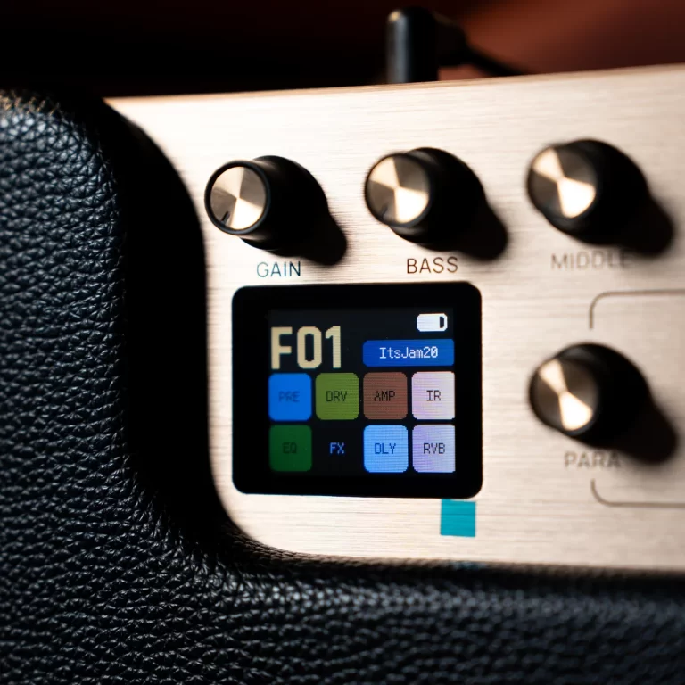 Close-up of a guitar amp control panel with Gain, Bass, and Middle knobs and a small color touchscreen display. ขายราคาพิเศษ