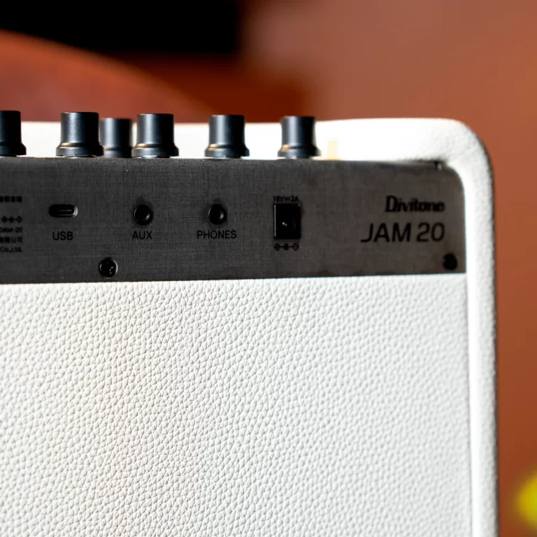 Close-up of a white Divitone JAM 20 guitar amplifier top panel with control knobs and inputs (USB, AUX, PHONES). ขายราคาพิเศษ