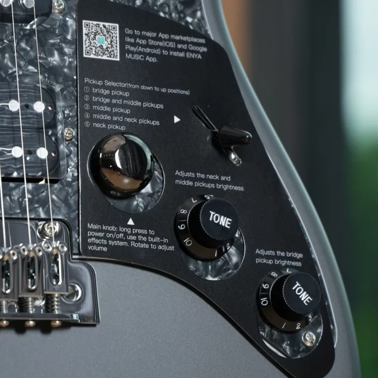 Close-up of a guitar's control panel showing the pickup selector, tone knobs, and printed instructions on a black plate from the guitar body. ขายราคาพิเศษ