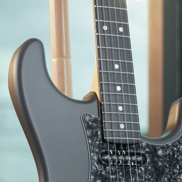Close-up of a gray electric guitar showing the body, neck, and strings with a black pearloid pickguard in the foreground. ขายราคาพิเศษ