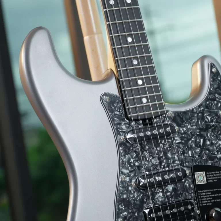 Close-up of a silver electric guitar body and fretboard with a black pearl-like pickguard and six strings centered in the image. ขายราคาพิเศษ