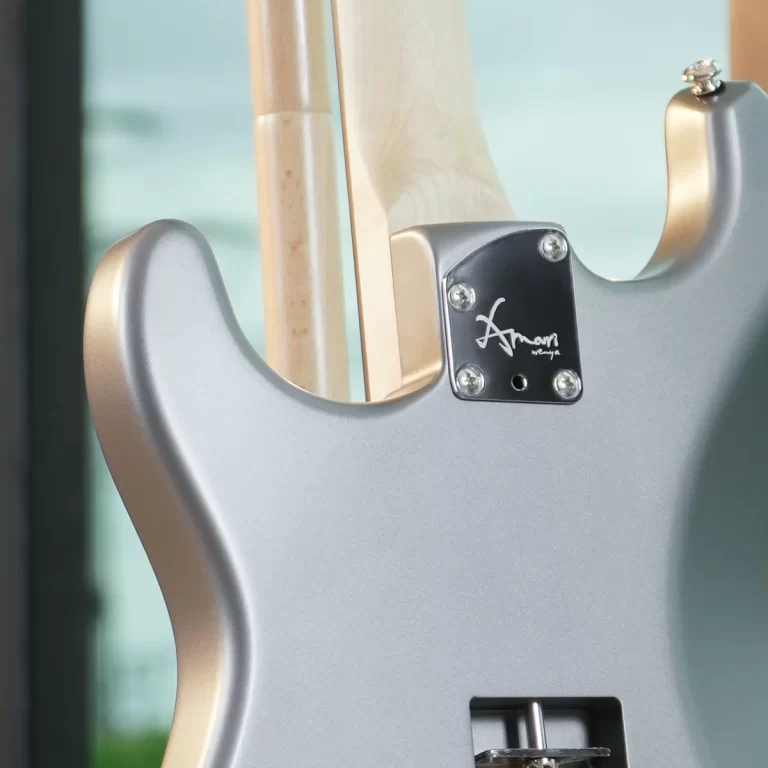 Close-up of a silver electric guitar back, showing a maple neck and chrome neck plate with a signature logo. ขายราคาพิเศษ