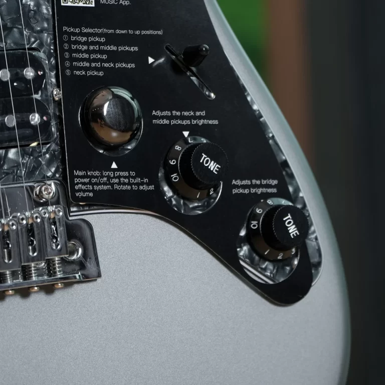 Close-up of an electric guitar body showing the control panel with tone knobs and a pickup selector; panel text explains pickup options and brightness adjustments. ขายราคาพิเศษ