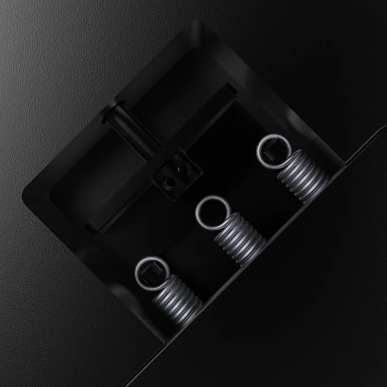 Close-up of a black mechanical housing with coiled springs and metal rings inside, viewed diagonally on a dark textured surface (industrial component). Micro-scale hardware detail for a locking or damping device. ขายราคาพิเศษ