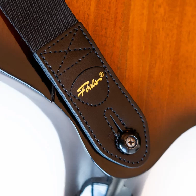 Close-up of a brown leather headphone headband with blue stitches and a gold embossed logo on the strap ขายราคาพิเศษ