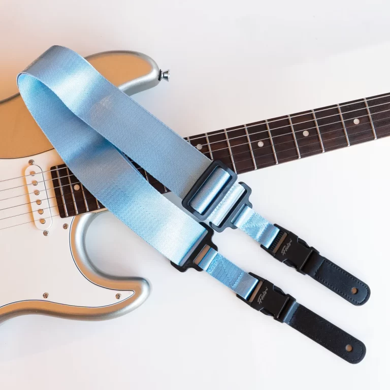 Electric guitar with a light blue strap draped over its body and neck. ขายราคาพิเศษ