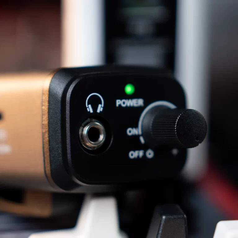 Close-up of a black audio device with a green power LED, a 3.5mm input jack, and a large power knob. ขายราคาพิเศษ