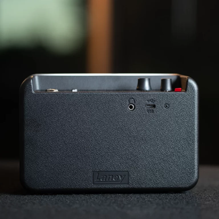 Back view of a black Laney compact amplifier showing a headphone jack, USB port, and small knobs on a textured surface ขายราคาพิเศษ