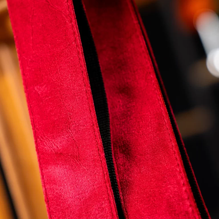 Close-up of red textured fabric with a black zipper running down the center. ขายราคาพิเศษ