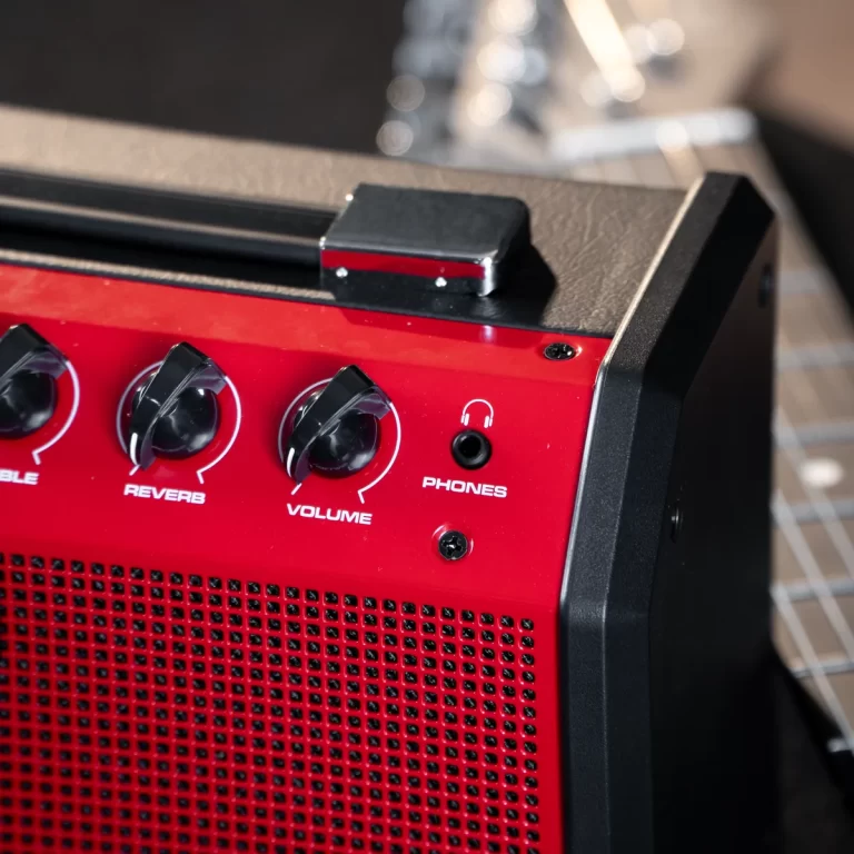 Close-up of a red guitar amplifier front panel with volume and reverb knobs and a PHONES headphone jack visible. ขายราคาพิเศษ