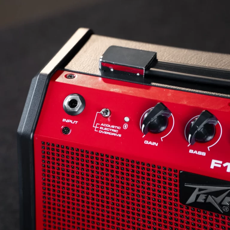 Red compact guitar amp front panel with input jack, two knobs labeled Gain and Bass, and an Acoustic Electric Overdrive label ขายราคาพิเศษ