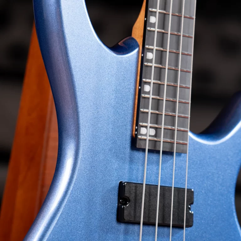 Close-up of a blue metallic electric guitar body with a maple neck, showing frets and strings in focus. ขายราคาพิเศษ