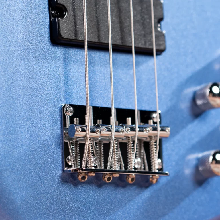 Close-up of a blue electric guitar bridge with six metal strings and chrome saddles. ขายราคาพิเศษ