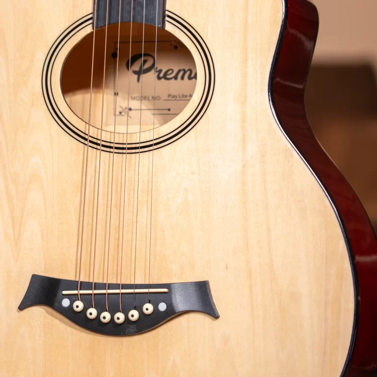 Close-up of an acoustic guitar body showing the sound hole and strings on a light wood top. Inside the soundhole, part of the 'Premier' label is visible. ขายราคาพิเศษ