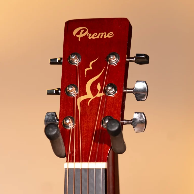 Close-up of a red guitar headstock with six chrome tuners and a gold flame graphic; brand reads 'Preme'. ขายราคาพิเศษ