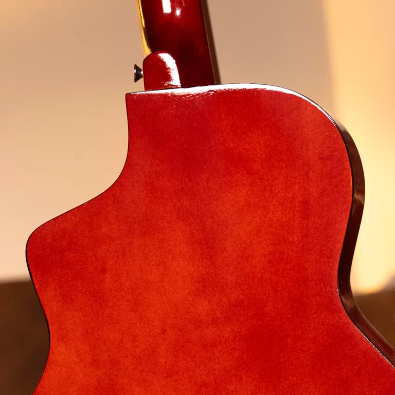 Close-up of a glossy red guitar body, highlighting the curved waist and neck joint area. ขายราคาพิเศษ