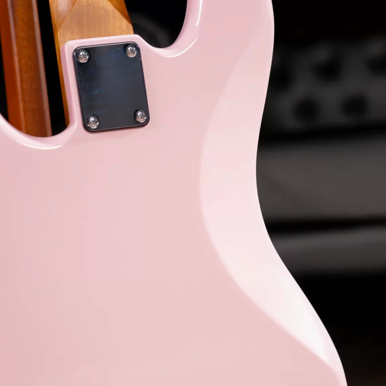 Close-up of a pink electric guitar body with a metal neck plate and four screws on the joint area. ขายราคาพิเศษ