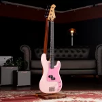 Pink electric bass guitar on a wooden stand in a cozy studio with a tufted sofa and small amplifiers in the background ขายราคาพิเศษ