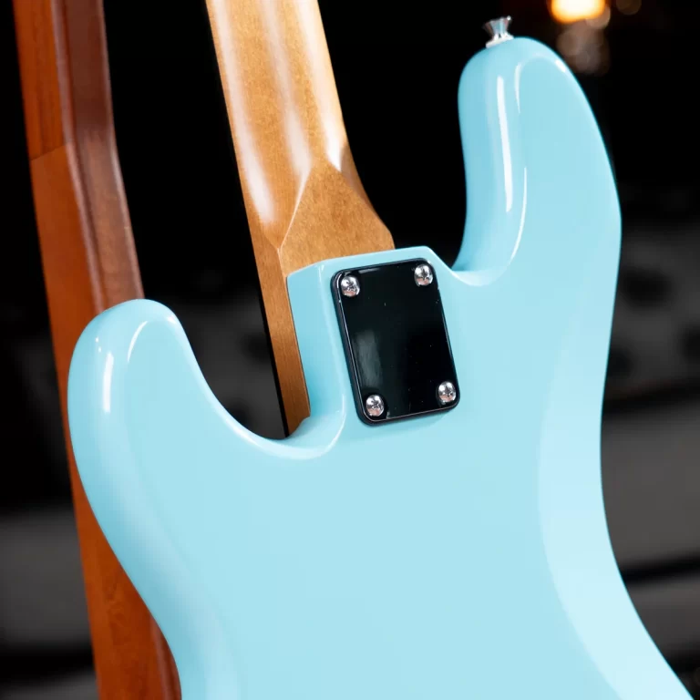 Close-up of a light blue electric guitar body with a wooden neck inserted into the neck joint plate ขายราคาพิเศษ