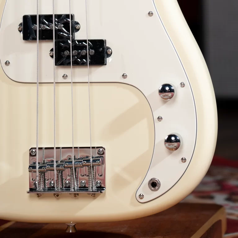 Close-up of a cream-colored electric guitar body with two black pickups, metal bridge, and several chrome control knobs on a wooden surface. ขายราคาพิเศษ