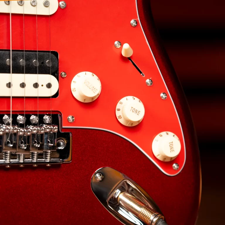 Close-up of a red electric guitar showing volume and tone knobs, pickup, and input jack. ขายราคาพิเศษ