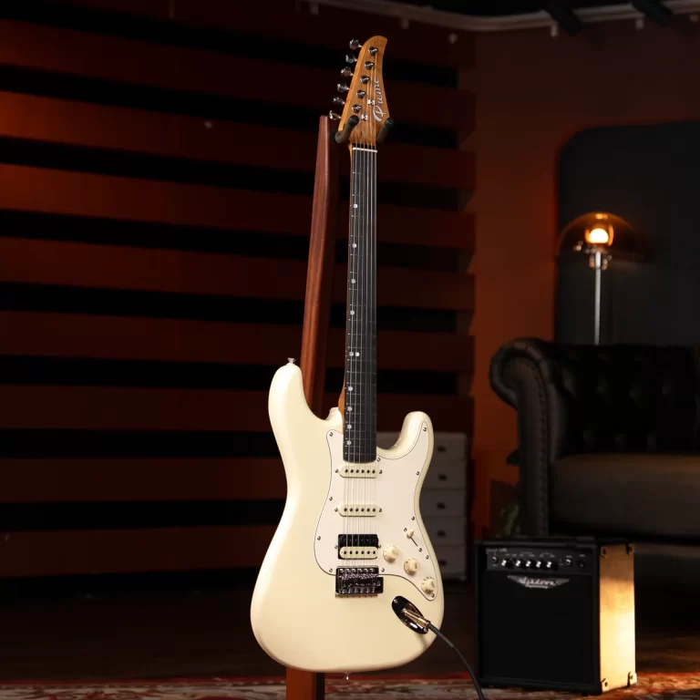 Cream Fender Stratocaster on a stand in a recording studio with an amp and lounge chair in the background. ขายราคาพิเศษ