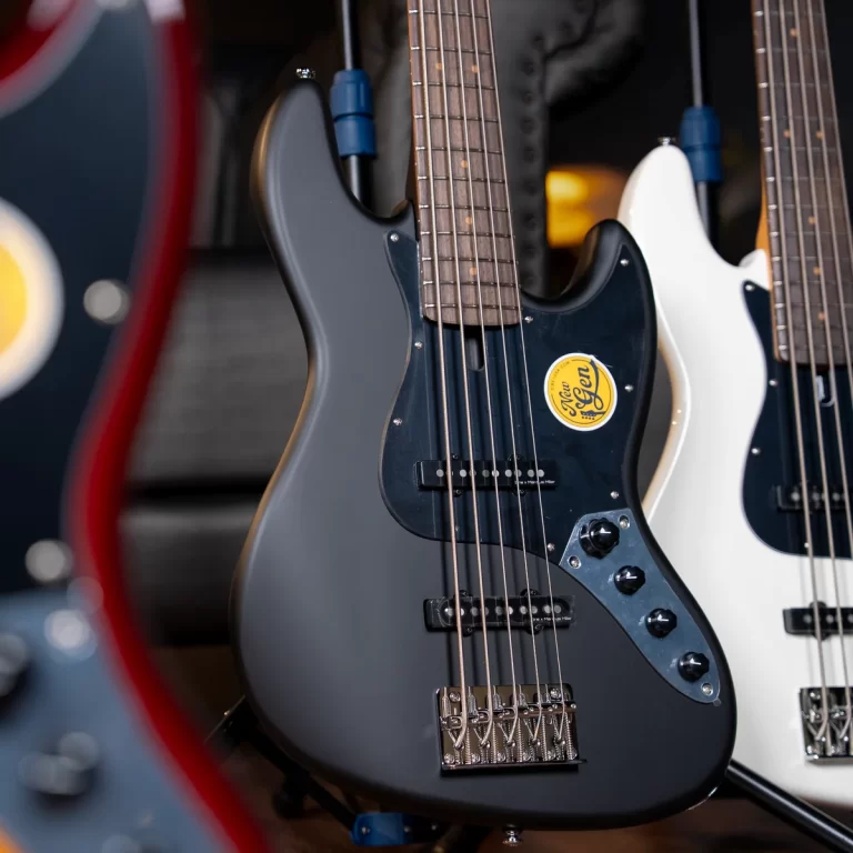 Close-up of a dark blue electric guitar on display, with strings, pickups, and a yellow sticker on the body. ขายราคาพิเศษ