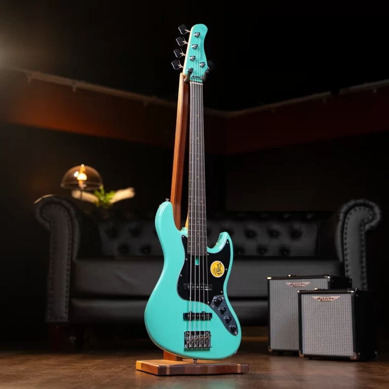 Turquoise electric guitar on a wooden stand in a dim room with a sofa and two small amplifiers in the background. ขายราคาพิเศษ