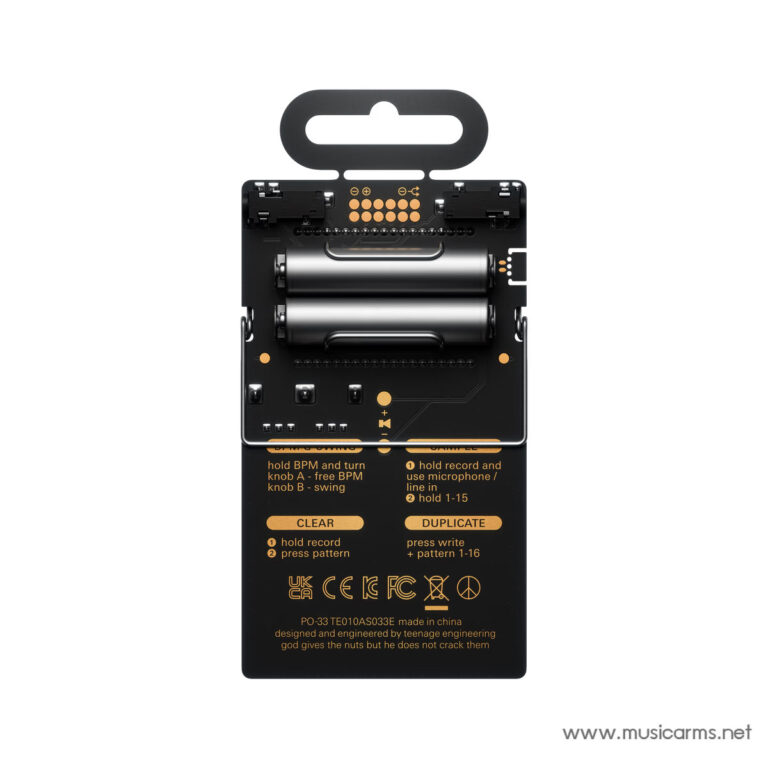 Back view of a small handheld electronic device showing two batteries, black housing, and orange labeling with small icons. Watermark www.musicarms.net visible bottom-right. ขายราคาพิเศษ