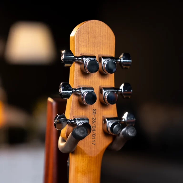 Close-up of a guitar headstock showing six chrome tuning pegs on a wooden neck. ขายราคาพิเศษ